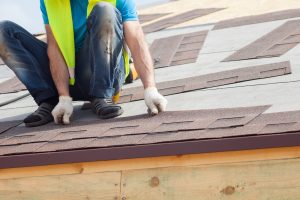 Roofer builder worker installing Asphalt Shingles
