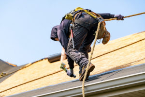 roofer using safety equipment on roof